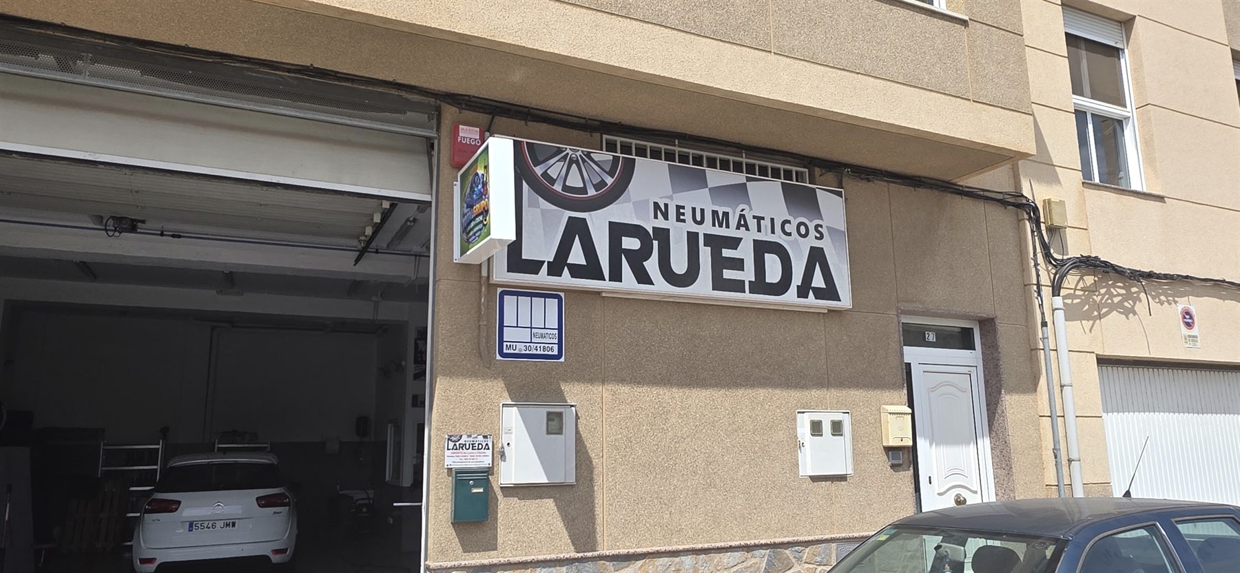 Fachada de Neumáticos La Rueda en la Calle El Rubial 27 de Águilas, con el rótulo sobre la puerta del taller