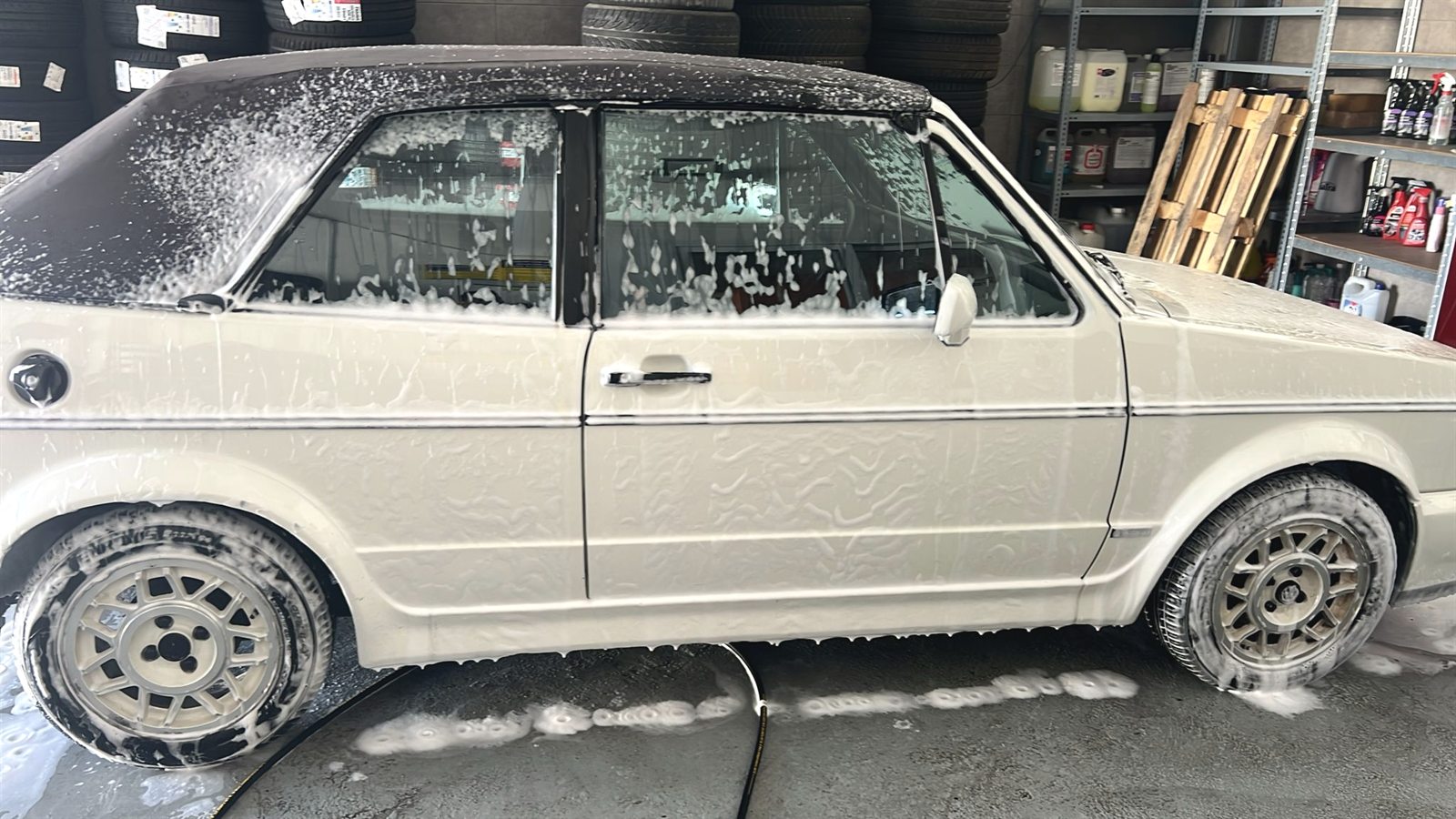 Volkswagen Golf Cabrio clásico cubierto de espuma en el box de lavado